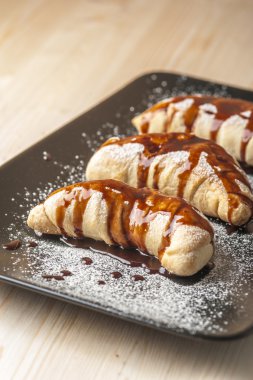 Çikolata sır ile kahverengi plaka üzerinde Puffs