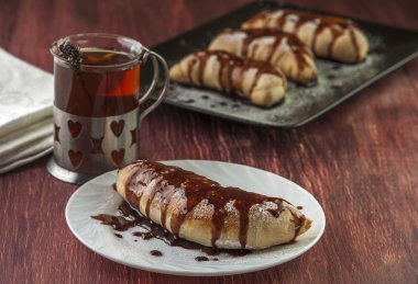 Fincan çay ve puf beyaz plaka üzerinde çikolata sır ile