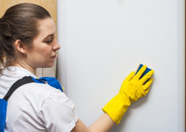 Kadın hademe buzdolabının kapısını sünger ile Temizleme