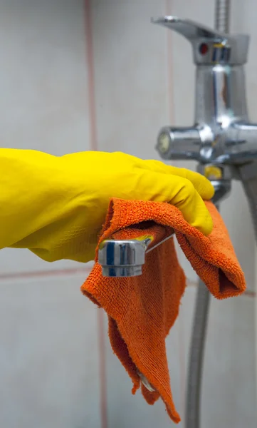 Primer plano de la mano de la mujer con el grifo de limpieza de guante amarillo — Foto de Stock