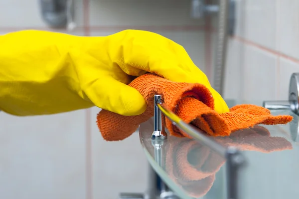 Fechar a mão da mulher na prateleira de banho de limpeza de luva amarela — Fotografia de Stock
