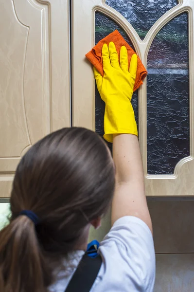 Mujer fregando armario de cocina con trapo — Foto de Stock