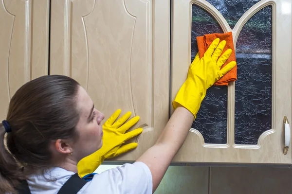 Mujer limpiando armario de cocina con trapo — Foto de Stock