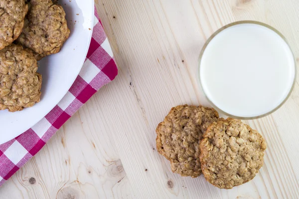 Placa con galletas de avena y vaso de leche —  Fotos de Stock