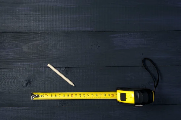 Roulette gialla e matita su tavole di legno — Foto Stock