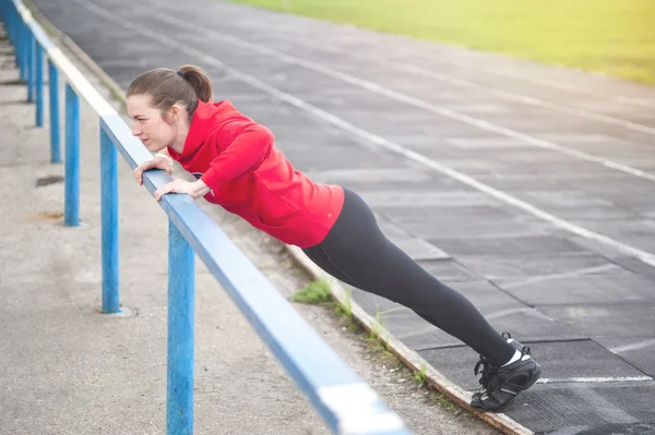 Young sporty woman doing push ups — Stock Photo, Image
