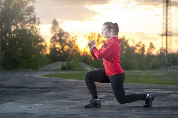 Mulher de sportswear fazendo agachamentos ao ar livre — Fotografia de Stock