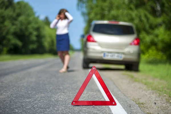 Red triangle sign and broken car on the roadside — Stock Photo, Image