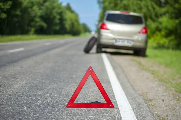 Broken car on the roadside, red triangle and spare wheel — Stock Photo, Image