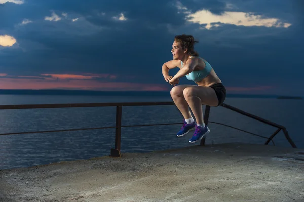 Uygun kadın iskelede plyometric egzersizleri yapıyor — Stok fotoğraf