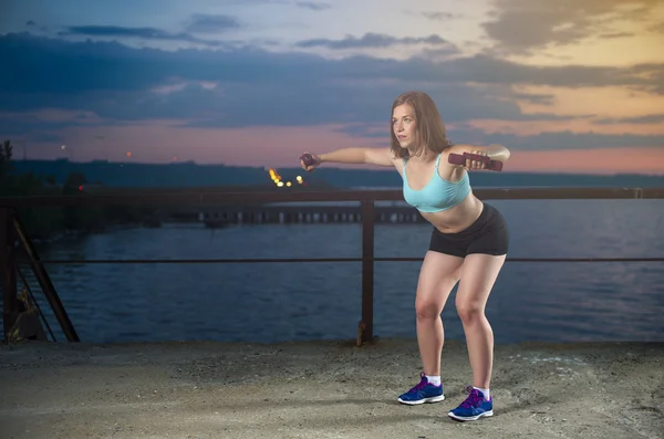 Fitness outdoors: woman exercising with dumbbells — Stock Photo, Image