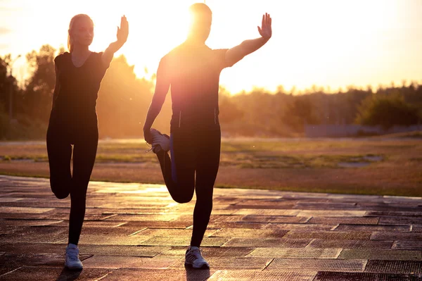 Silhouetten junger Erwachsener beim Sport bei Sonnenuntergang — Stockfoto