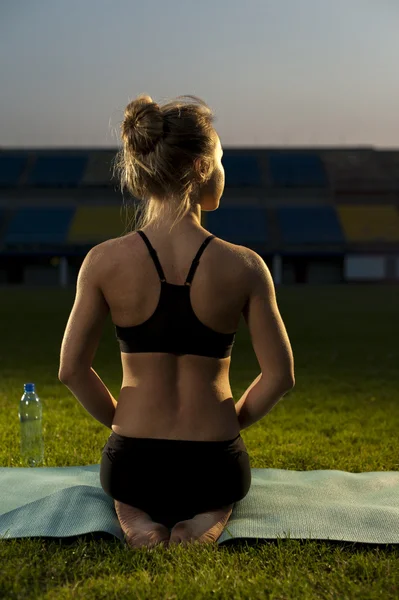 Fit blonde woman practicing yoga outdoors — Stock Photo, Image