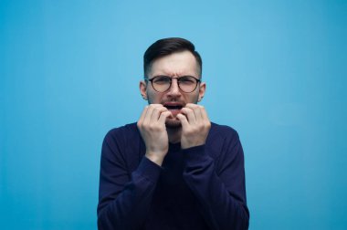 Gözlüklü genç adam korkuyor.