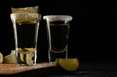 Limon dilimleri ve tuzlu Meksika Altın Tekilası.