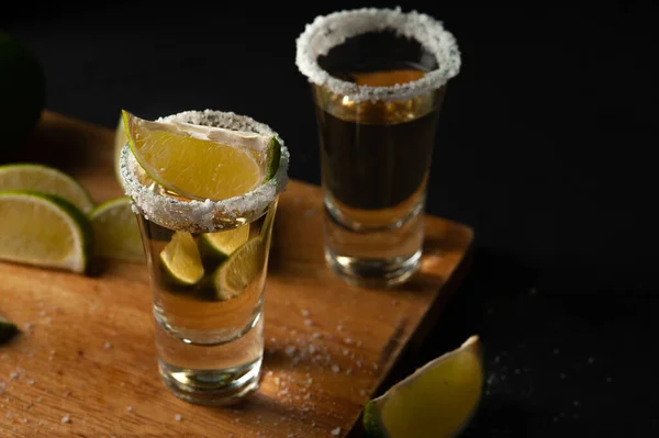 Tequila mexicana Ouro em copos com fatias de limão e sal. — Fotografia de Stock