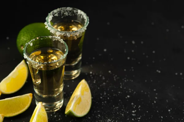 Tequila de oro mexicano con rodajas de lima y sal. — Foto de Stock