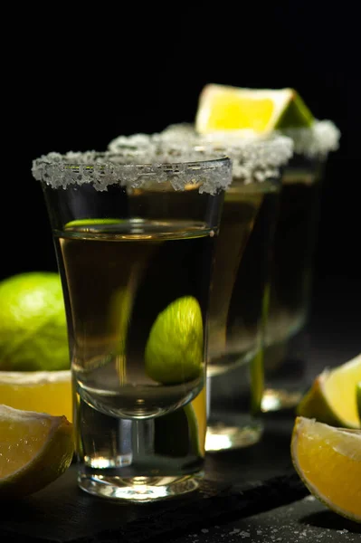 Mexican Tequila Gold in glasses with lime slices and salt. — Stock Photo, Image