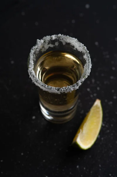 Gouden Mexicaanse tequila shot met limoenschijfje en zout. — Stockfoto