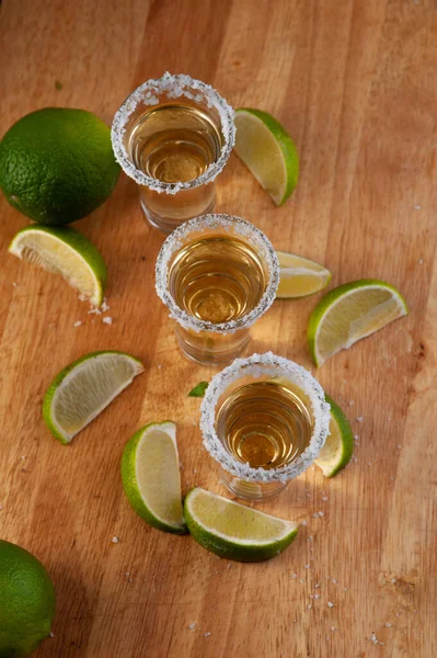 Mexicaanse gouden tequila met limoenschijfjes en zout, bovenaanzicht — Stockfoto