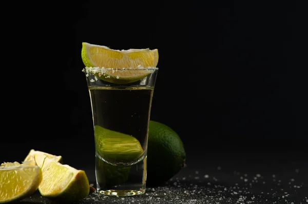 Gouden Mexicaanse tequila shot met limoenschijfje en zout. — Stockfoto