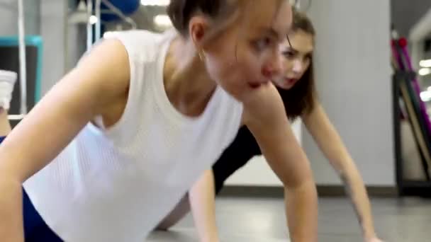 Gyönyörű fiatal nők Fitness szerelmeseinek jegyesek a tornateremben — Stock videók
