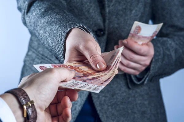 Gri takım elbiseli kadına birine para verir