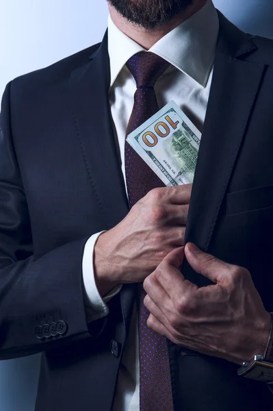 Homem barbudo em terno remove dinheiro para o bolso — Fotografia de Stock