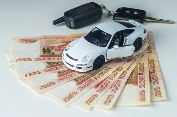 Oyuncak araba, beyaz arka plan üzerinde banknot ve araba anahtar