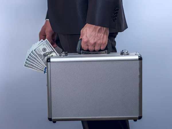 Mann im Anzug trägt Aktentasche aus Metall mit Dollars — Stockfoto
