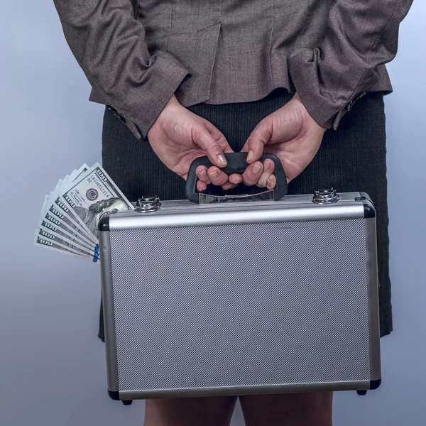 Vrouw houdt een koffer met geld achter de rug — Stockfoto