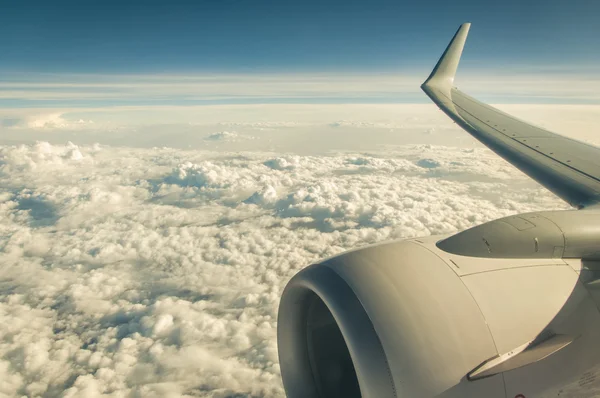 Airplane wing and jets engine in the sky