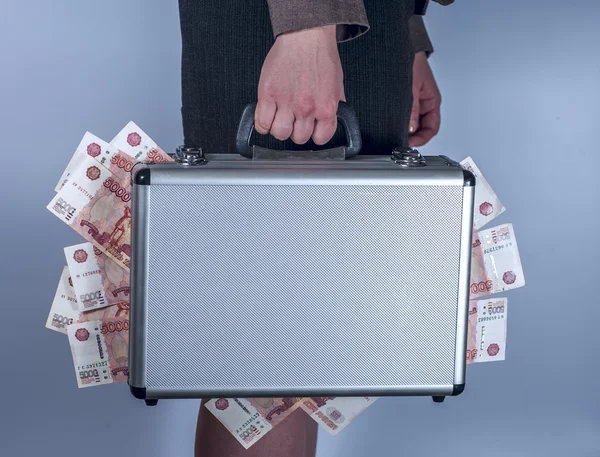 Woman in suit carries metal briefcase with rubles