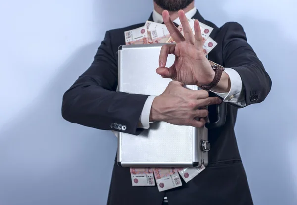 Homem de fato tem uma pasta de metal cheia de dinheiro. — Fotografia de Stock