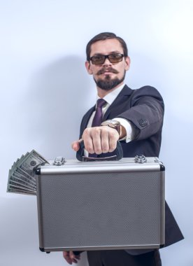Man with eyeglasses holding a suitcase of money