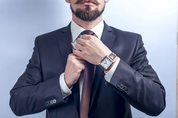Bearded man straightens his tie