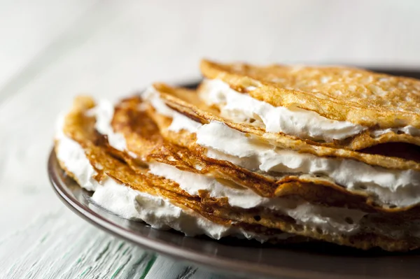 Pfannkuchen mit Schlagsahne auf braunem Teller — Stockfoto