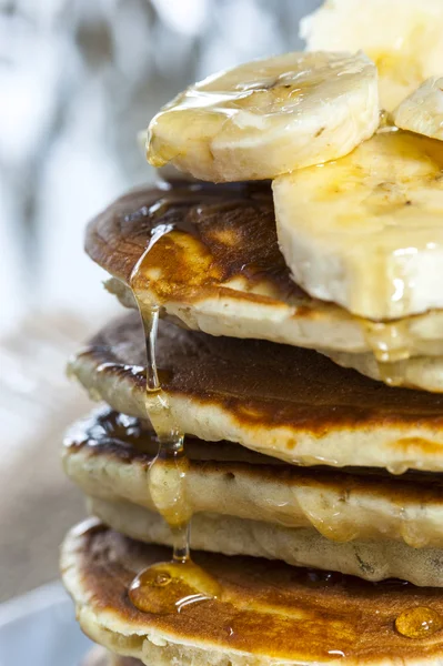 Stack of homemade pancakes with banana slices and honey, close up — Stock Photo, Image