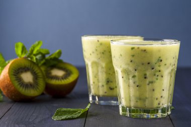 Kivi, muz ve nane yaprakları ile ev yapımı güler yüzlü iki kadeh. Sağlıklı gıda anlayışı. Alkolsüz içecekler.