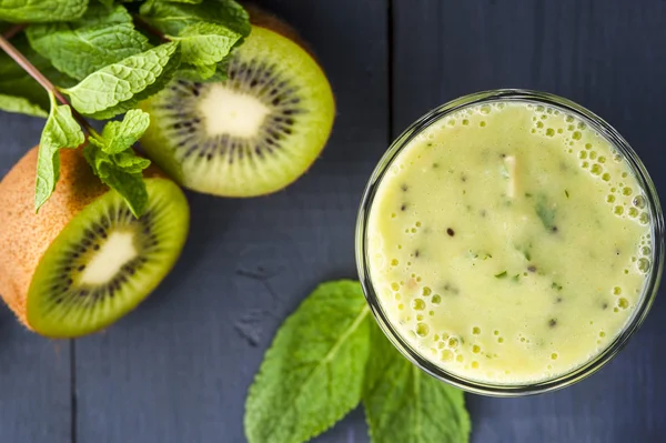 Segelas smoothie buatan sendiri dengan kiwi, pisang dan daun mint. Pembuatan makanan sehat. Minuman non-alkohol . — Stok Foto