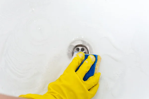 Mano en guante amarillo con esponja, limpiando el baño. Concepto de limpieza . — Foto de Stock