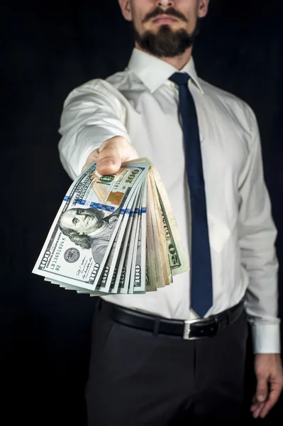 Zakenman die houdt een prop van geld, ons dollar biljetten. Financieel thema. — Stockfoto