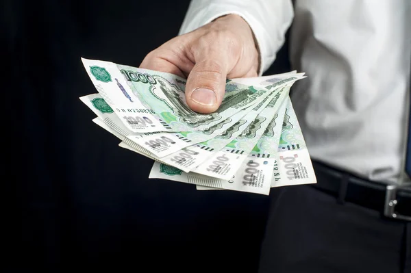 Geschäftsmann, der ein Bündel Geld in der Hand hält, russische Rubel-Banknoten. Finanzthema. — Stockfoto