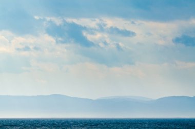St. Lawrence nehrindeki yelkenlinin üstündeki karanlık gökyüzünde güneş ışığı.