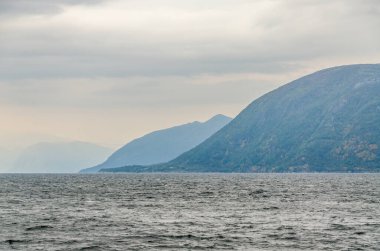 Hava bulutluyken fiyort sonbahar manzarası. (Norveç)