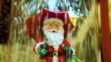 Kar altında şemsiyesi olan oyuncak Noel Baba
