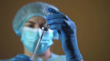 Lastik eldivenli doktor şırıngayı cam şişeden alınan ilaçla doldurup kapat.
