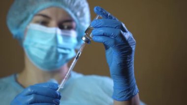 Lastik eldivenli doktor şırıngayı cam şişeden alınan ilaçla doldurup kapat.