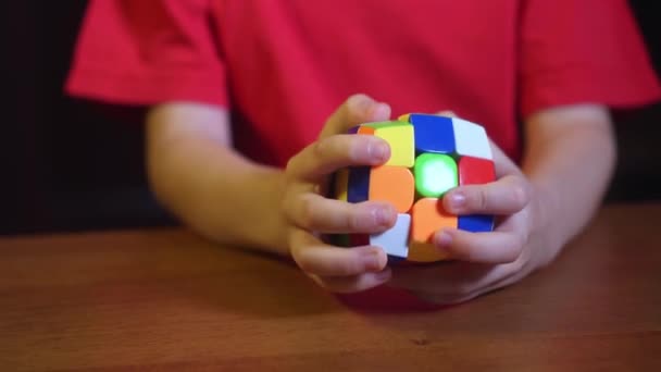 Nahaufnahme von kleinem Jungen spielt einen Entwicklungsgeist und Schlagfertigkeit Spielzeug Rubiks Cube — Stockvideo