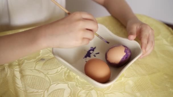 Frohe Osterfeiertage. Schöne kaukasische Junge malen und dekorieren Eier.